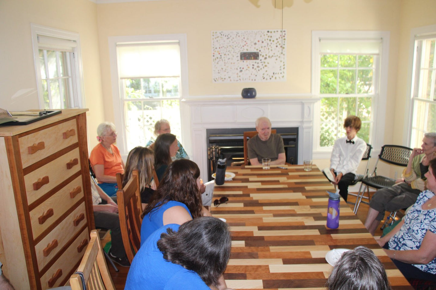 The author Daniel Quinn speaking and answering questions in Erik's home. A mixed wood dining table was declared "Daniel Quinn worthy" by Quinn's longtime assistant Howie (shown to the left). Image is from meetup.com website.